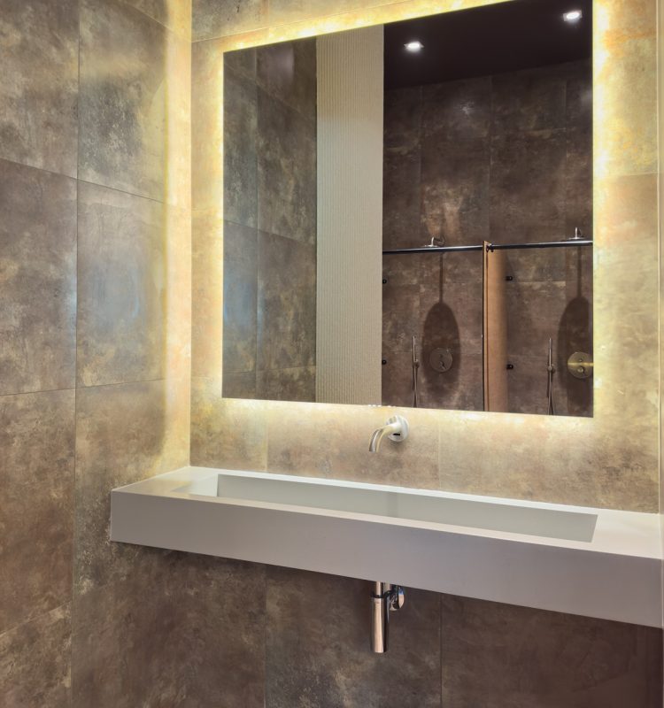 Modern spa bathroom with a large integrated sink and backlit mirror. Stone tiles and clean lines emphasize a premium minimalist mood. SSUCv3H4sIAAAAAAAAA41PQY6DMAz8i88gJdClga9UPQRiqFVKqsRstUL5+zqUaq+b04wnnhlvQA460K4x+qtV5dnVdan1qErTN6Yc9VidXVs1rVFQgLOM0On6pJTWtalOTW2UvAJ6G2mAbgOa5zVysEx+gU6UgIvDsEN0xD6QnYWlAiJbXiNGWRM2iPck6s4/fpctz6WghMe1zyAV/5xdC7ATLsNP9k+5yIx2j7uIdH8xhseR7fmWK2b4DDTQMh2d5BT/eOPFc97dE9gPd3LH8vuMG8k05CxYn7O3Dt0hr/2DmD804Dfh6+93SukXyQ3NM4QBAAA=
